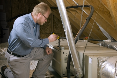 man checking furnace on the attic